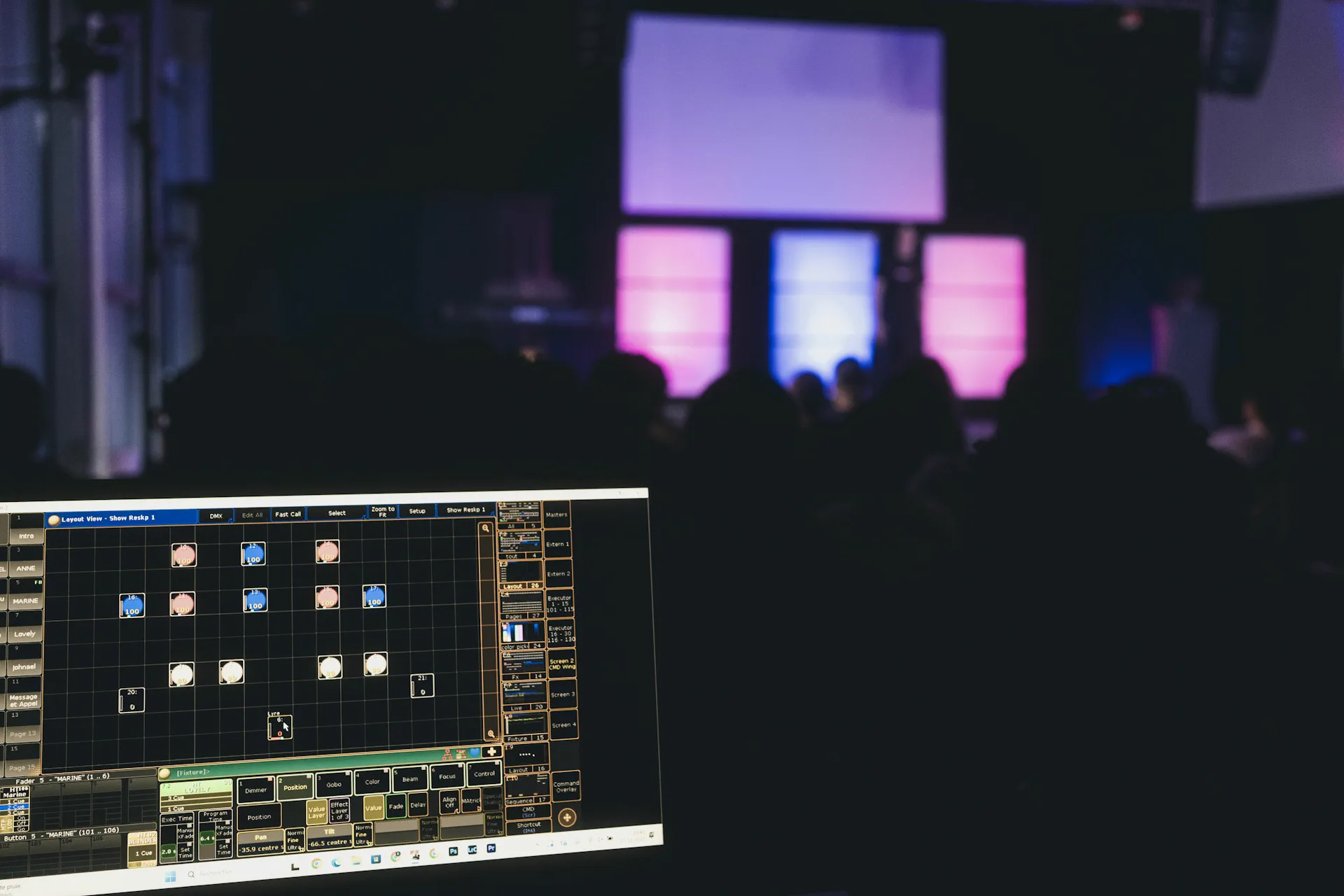 Stage lighting control screen overlooking a live event.